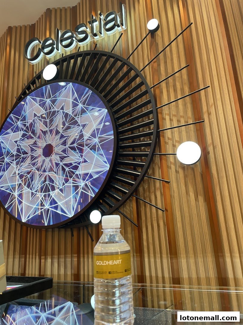 A bottle of Goldheart water is placed in front of a decorative wall display with the word 'Celestial'.