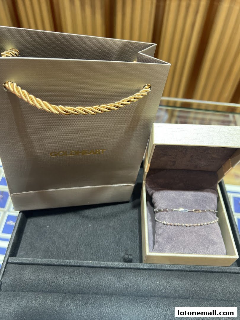 A Goldheart jewelry shopping bag and an open jewelry box with a bracelet.