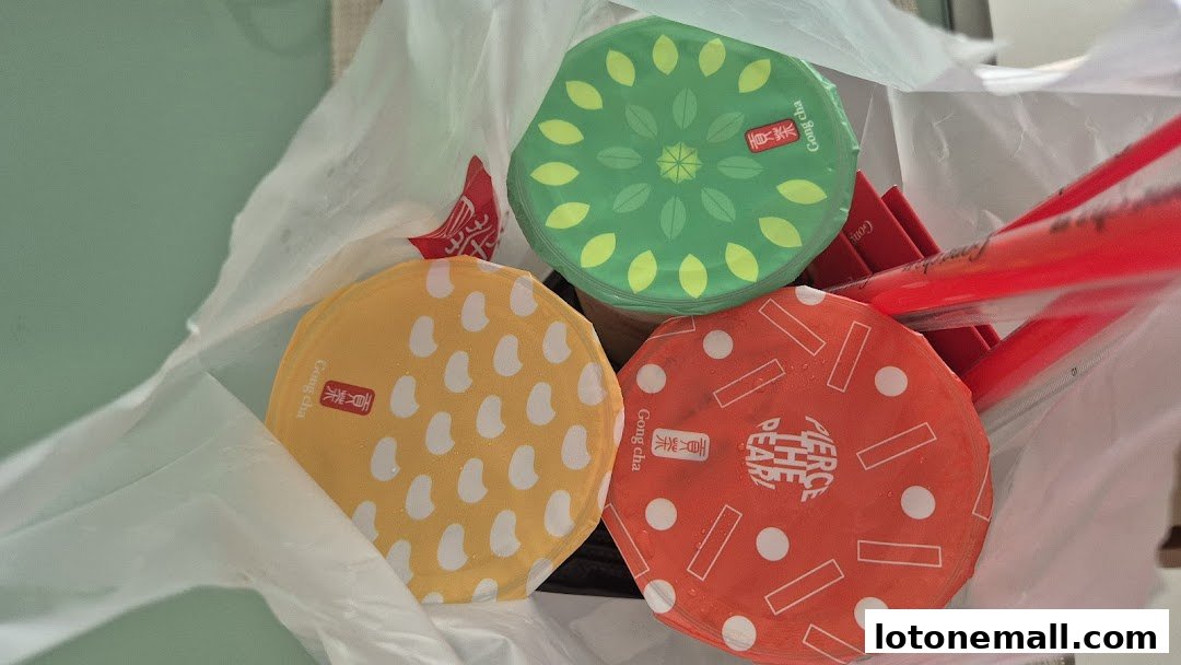 Three colorful bubble tea drinks from Gong Cha in a white plastic bag.