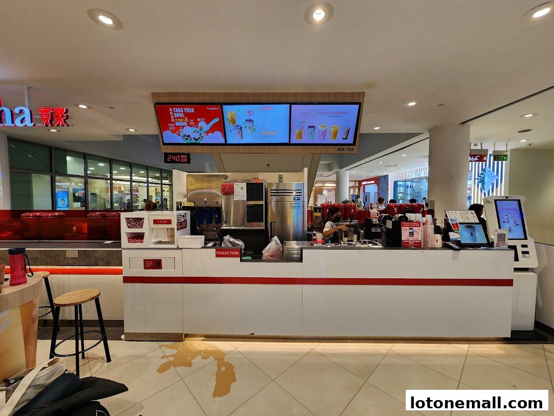 A Gong Cha bubble tea shop counter with staff preparing drinks and digital menu boards above.