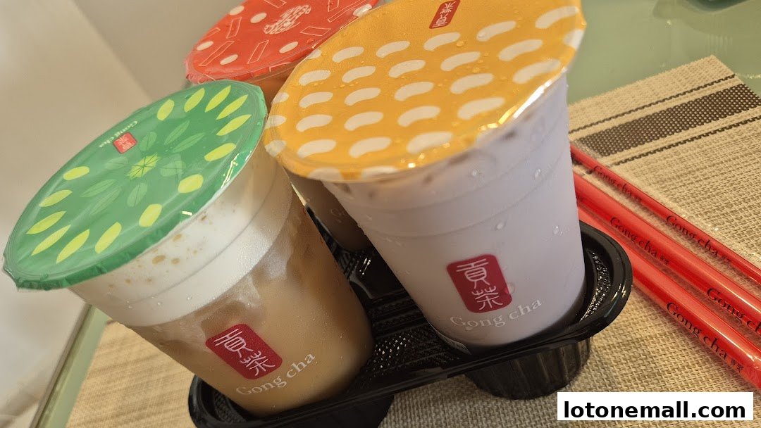 Three colorful bubble tea drinks from Gong Cha are displayed with red chopsticks.