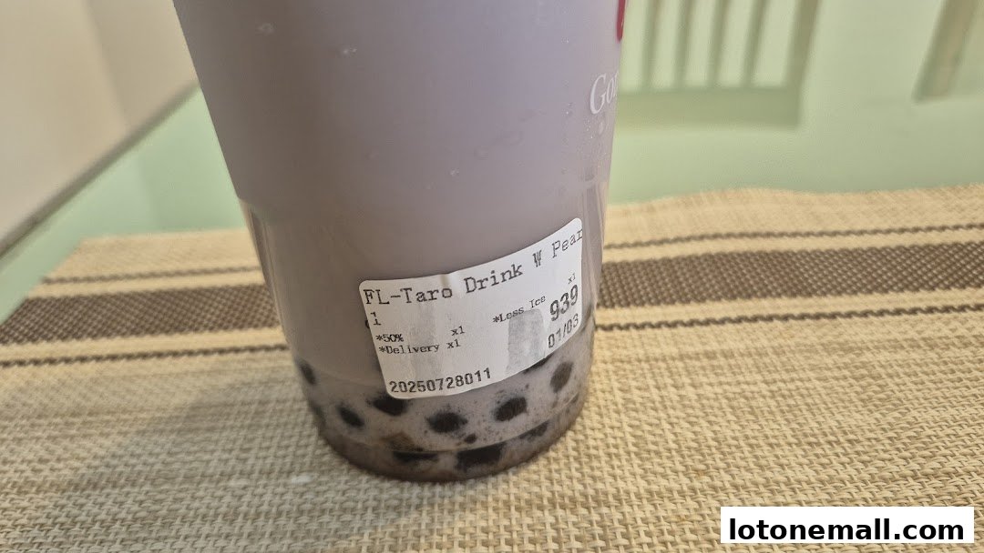A close-up of a purple taro bubble tea with a label showing order details.