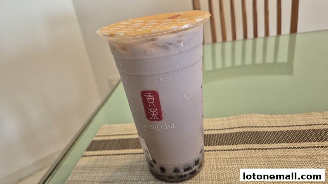 A tall cup of purple bubble tea with tapioca pearls at the bottom, from Gong Cha.