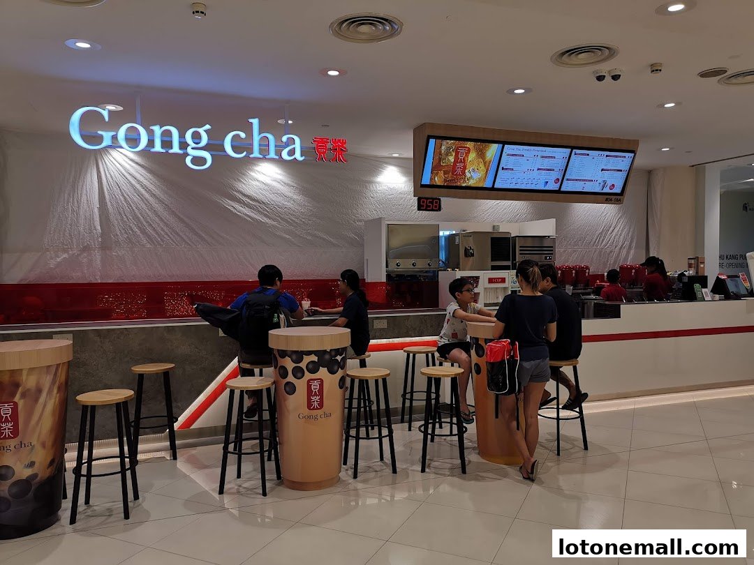 People sitting at a Gong Cha bubble tea shop with a menu board and counter visible.