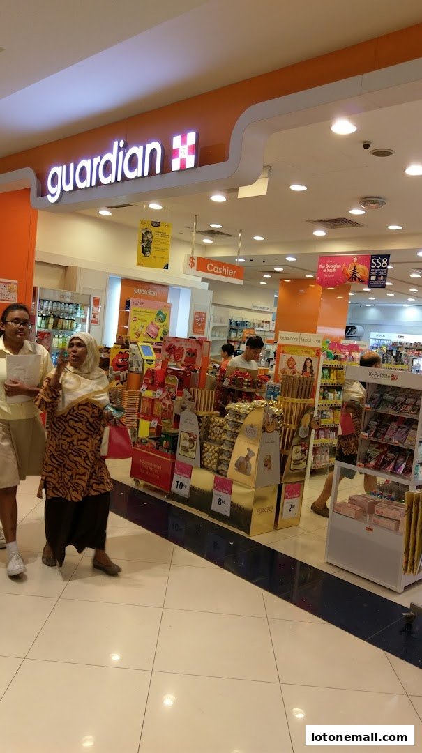 Guardian Health & Beauty Pharmacy entrance with displays of chocolates and health products.