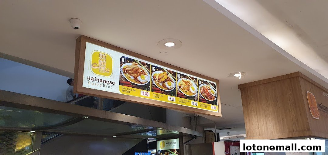 A brightly lit menu board showcasing Hainanese Curry Rice dishes with prices.