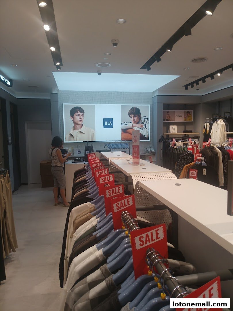 Interior of a clothing store with racks of sale items and promotional displays.