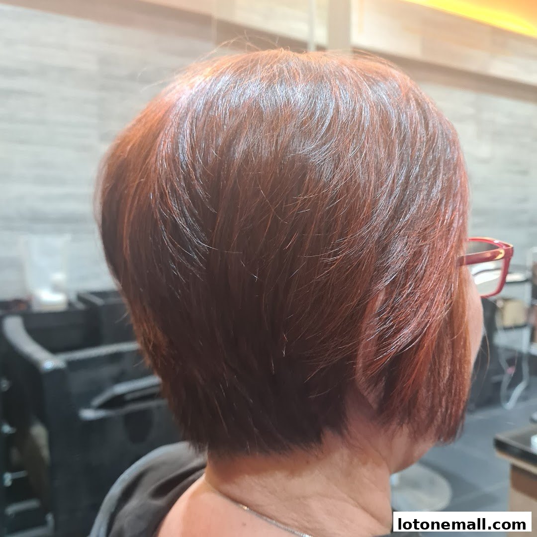 A woman with short, reddish-brown hair styled in layers, viewed from the back.