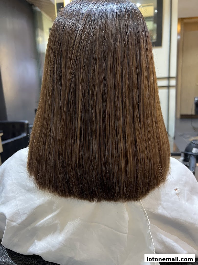A person's freshly cut, straight brown hair styled in a bob.
