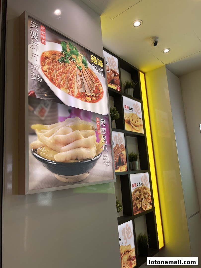 Illuminated display boards showcasing various appetizing Chinese dishes, including tripe and chicken feet.