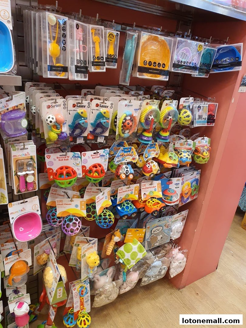A display of colorful baby and toddler toys, including rattles, balls, and plush items.