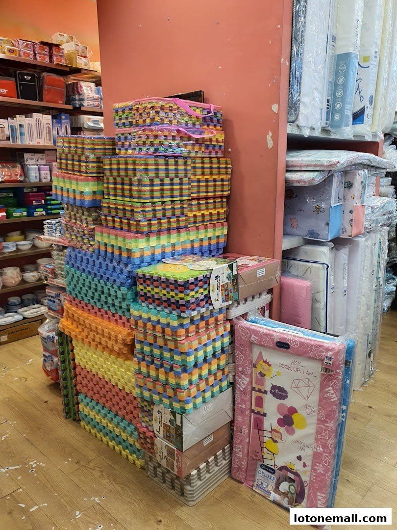 A shop interior displaying stacks of colorful foam play mats and other children's items.