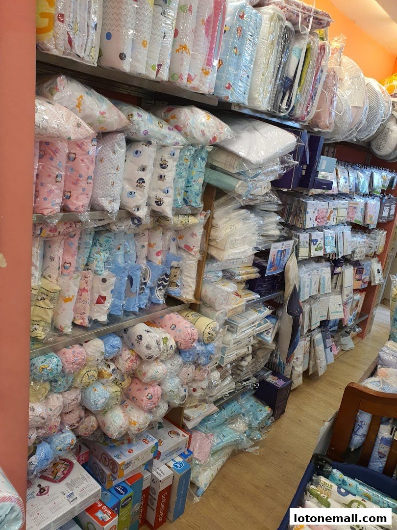 Shelves stocked with baby bedding, blankets, and clothing in colorful packaging.