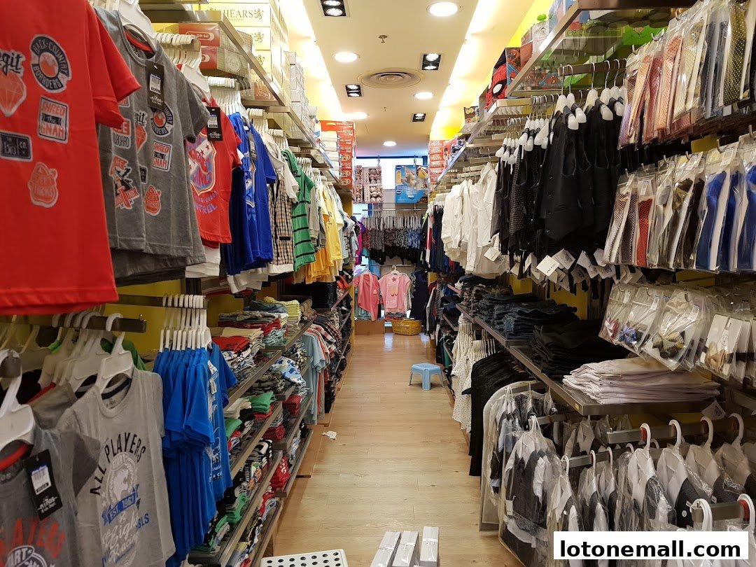 A well-stocked children's clothing store with racks of colorful t-shirts, shirts, and accessories.