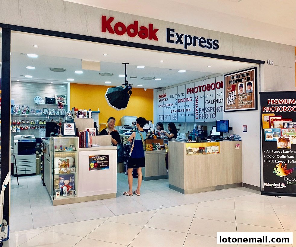 Kodak Express shop front with services like photo printing, photobooks, and passport photos.