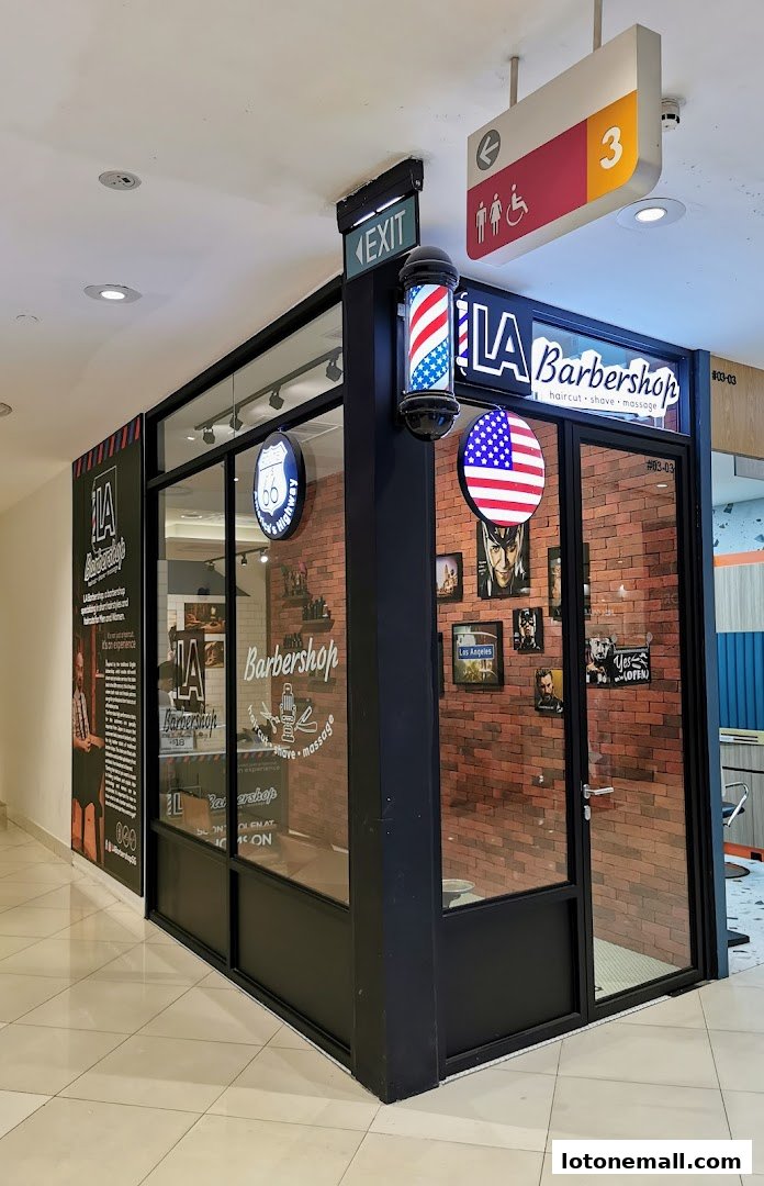 The exterior of LA Barbershop, featuring a classic barber pole and American flag decor.