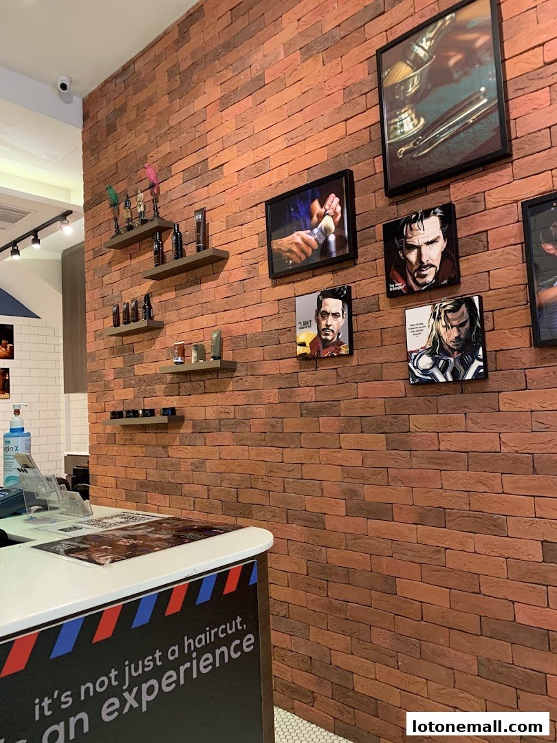Interior of a barbershop with brick walls, shelves of products, and framed artwork.