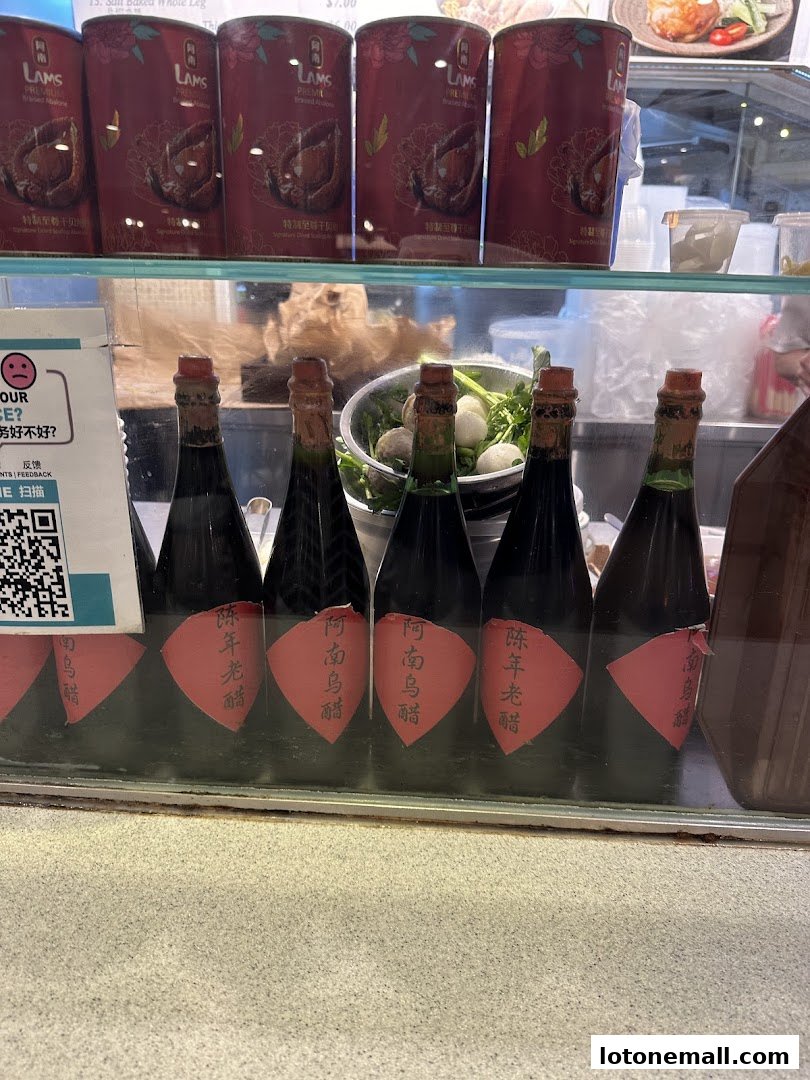 Bottles of vinegar and cans of abalone are displayed behind a glass counter.