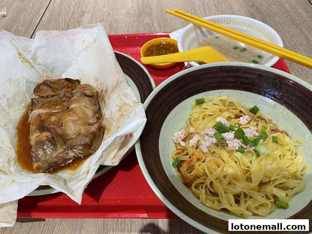 A bowl of noodles with minced meat and spring onions, served with salt-baked chicken and dipping sauce.