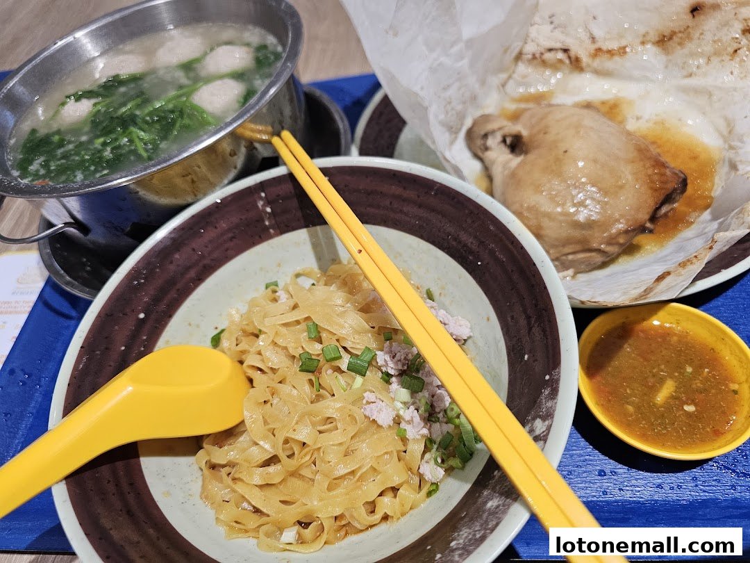 A close-up of a delicious meal featuring noodles, salt-baked chicken, and soup.