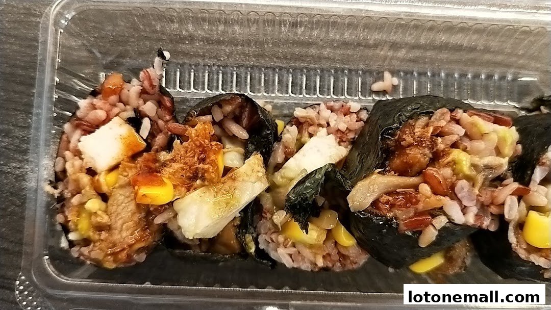 Close-up of several Maki-San sushi rolls in a clear plastic container.
