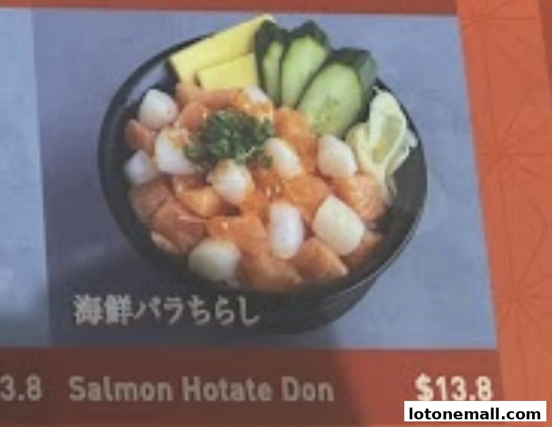 A close-up of a Salmon Hotate Don dish with salmon, scallops, cucumber, and tamagoyaki.