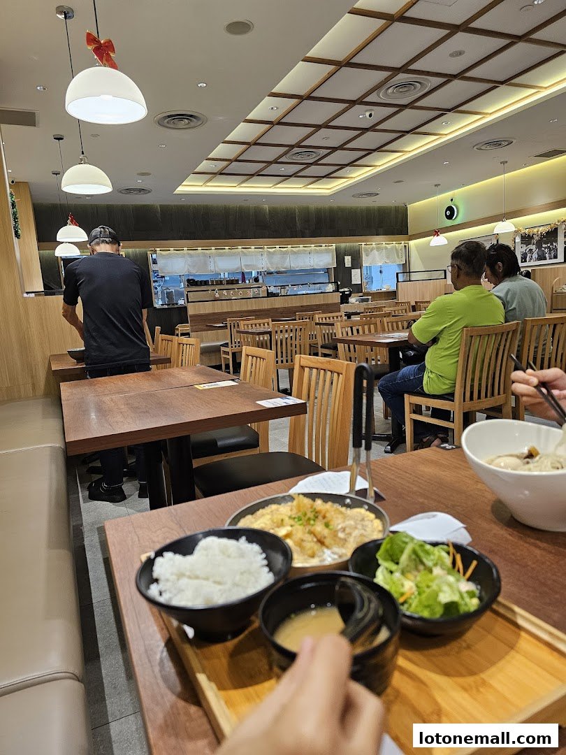 Interior of a Japanese restaurant with diners and food on tables.