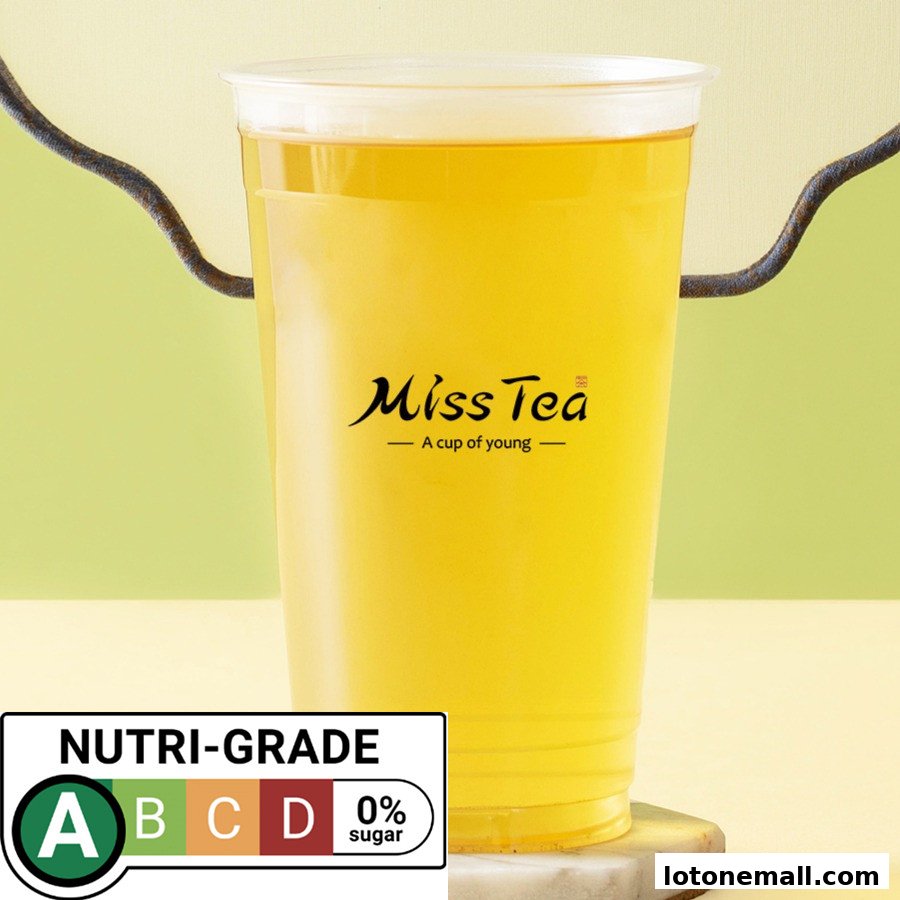 A clear plastic cup of yellow tea with the Miss Tea logo and a Nutri-Grade label.