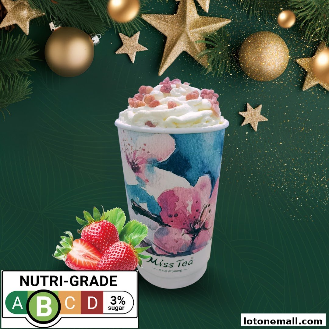 A festive beverage from Miss Tea with whipped cream, toppings, and strawberries, alongside holiday decorations.