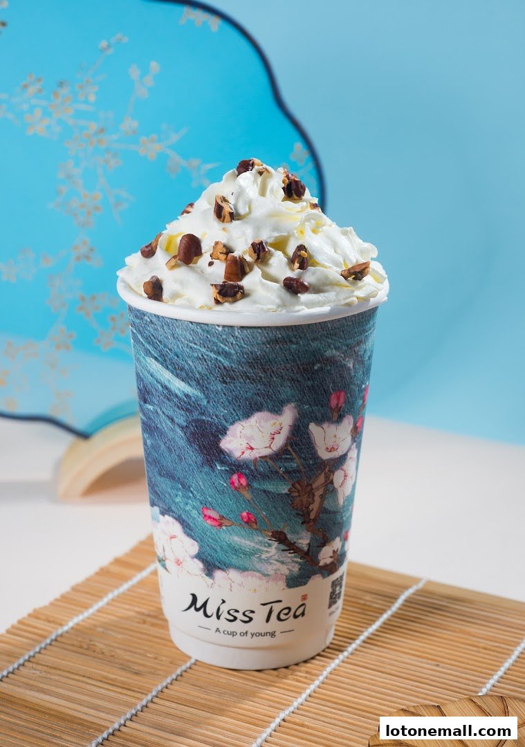 A close-up of a delicious beverage from Miss Tea, topped with whipped cream and nuts.