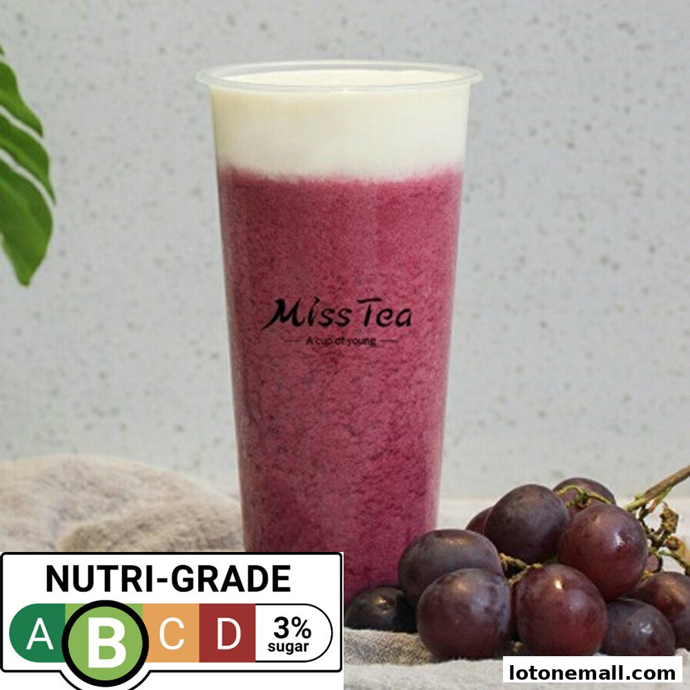 A tall cup of purple smoothie with a creamy top, next to grapes and a Nutri-Grade label.