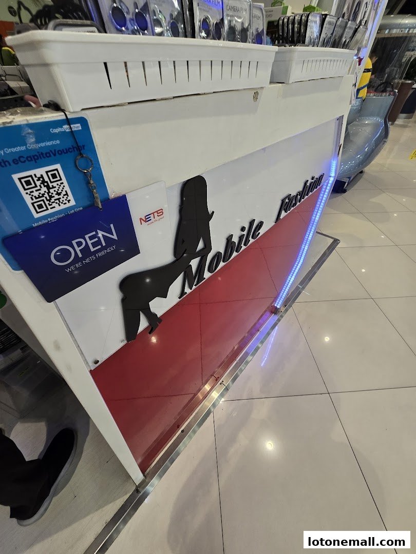 The front of a mobile accessories shop called Mobile Fashion, with an open sign and product displays.