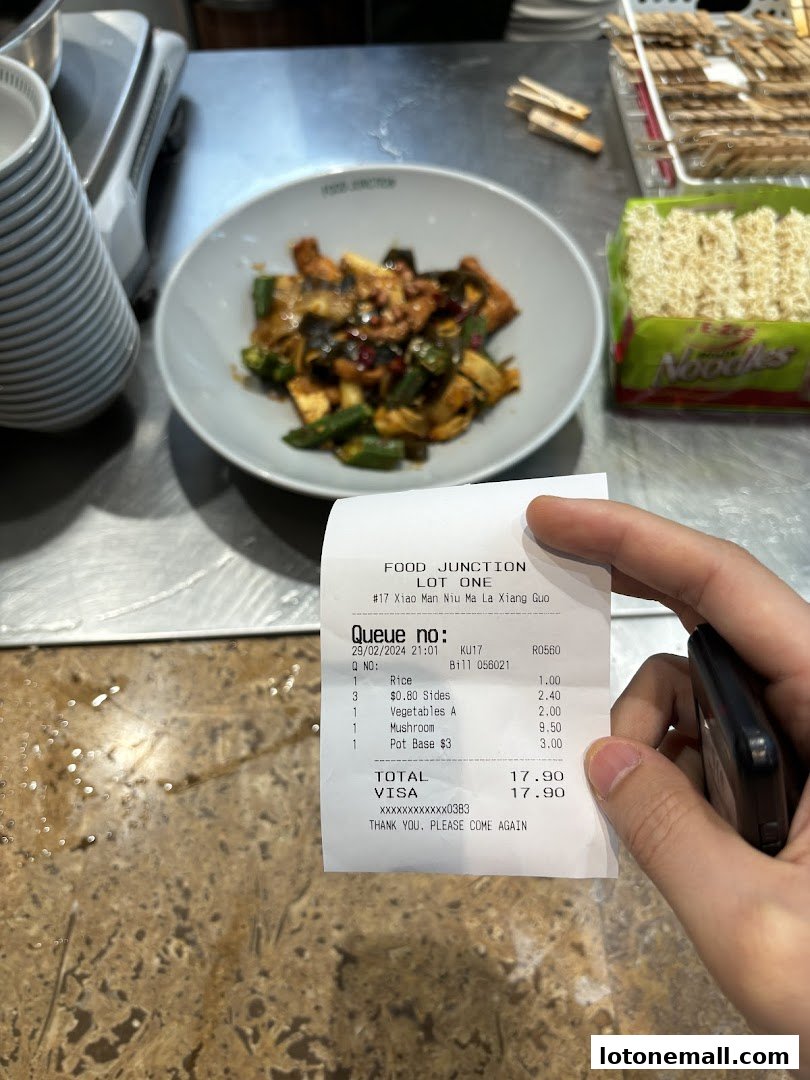 A receipt from Food Junction Lot One showing a meal with rice, sides, vegetables, mushroom, and pot base.