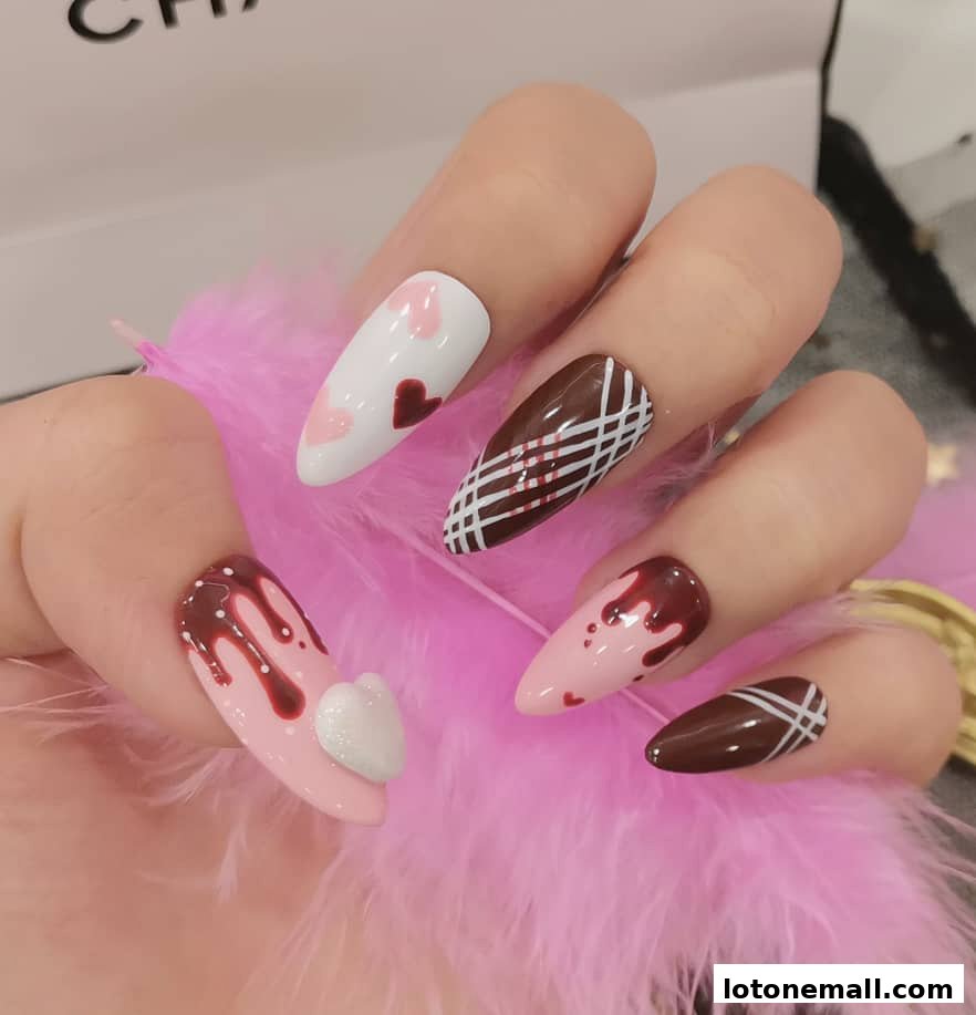 A hand with intricately designed nails featuring hearts and chocolate-like patterns.