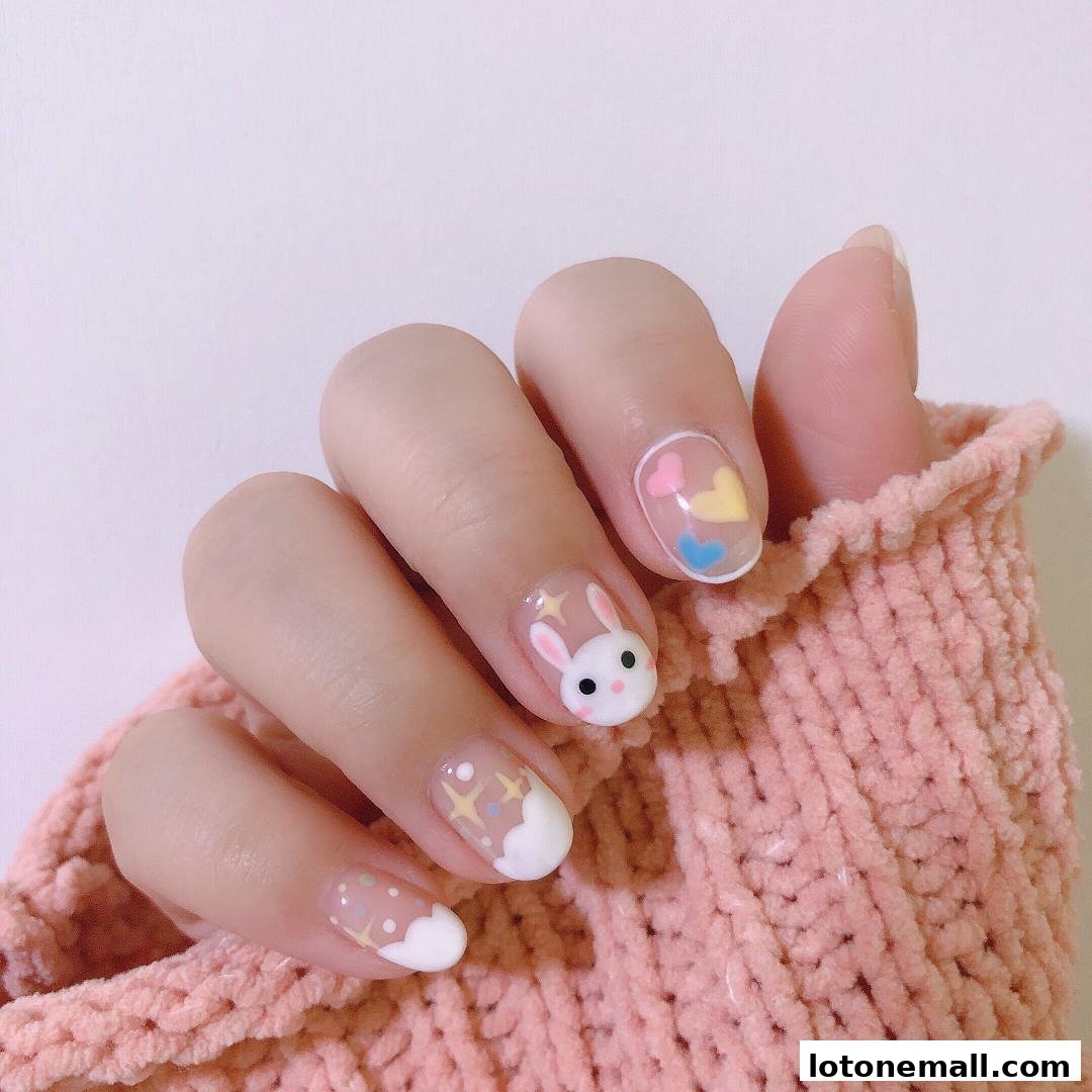 A hand with cute bunny and heart nail art, wearing a pink knitted sweater.