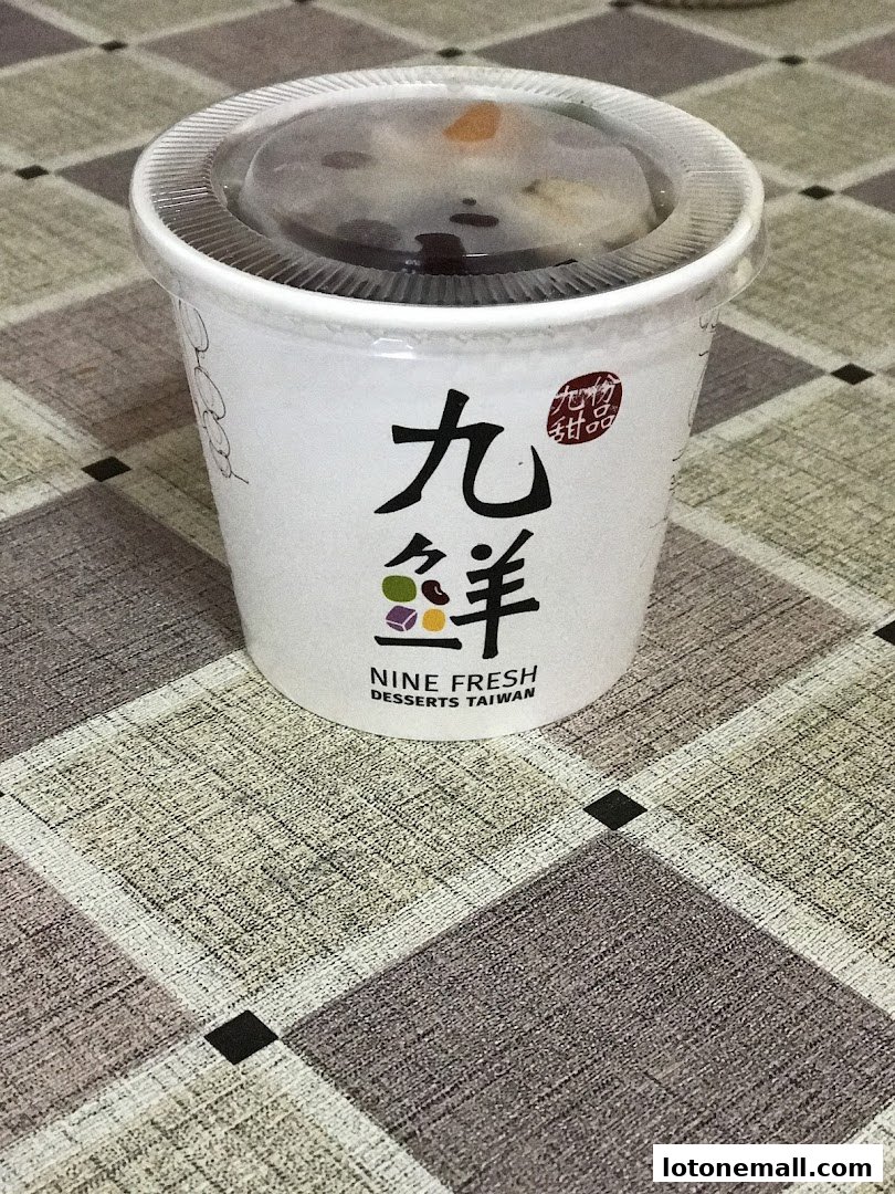 A cup of dessert from Nine Fresh Desserts Taiwan with its logo visible.