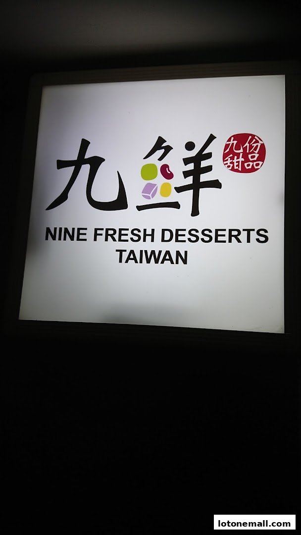 A lit sign for Nine Fresh Desserts Taiwan with Chinese characters and colorful dessert icons.
