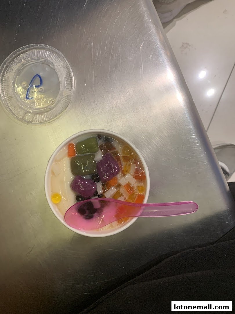 A bowl of Taiwanese dessert with various toppings and a pink spoon.