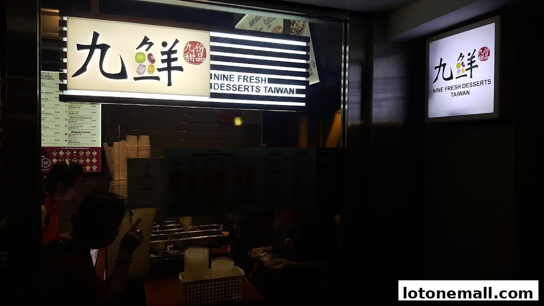 The exterior of Nine Fresh Desserts Taiwan, showcasing its illuminated signage and a glimpse of the menu.