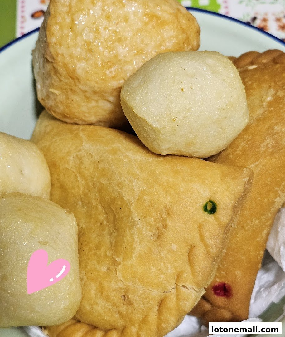 A close-up shot of various fried snacks, including fish balls and pastries.
