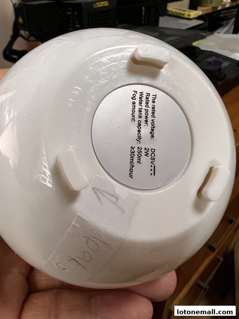 Close-up of the bottom of a white humidifier with a label showing specifications.