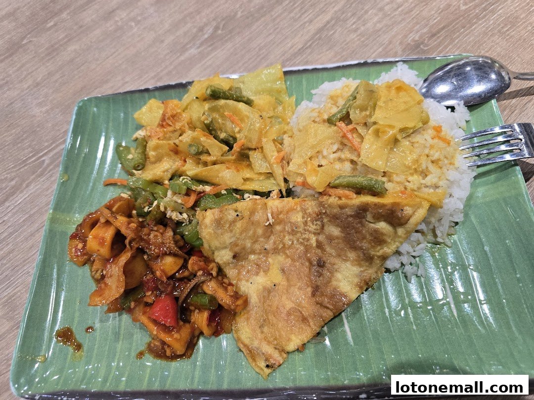 A plate of rice with various side dishes including vegetables and an omelet.