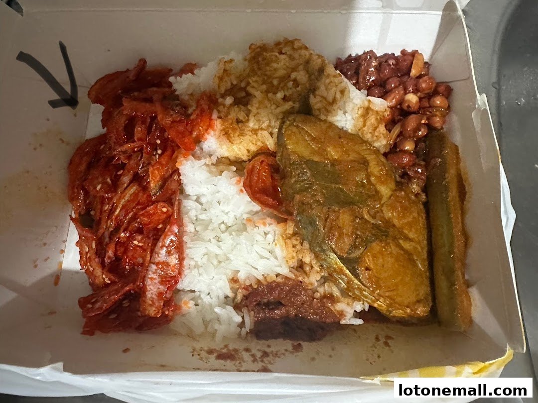 A takeaway box filled with rice, fish, anchovies, peanuts, and vegetables.