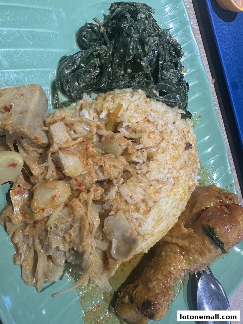 A plate of rice with chicken, vegetables, and jackfruit curry.