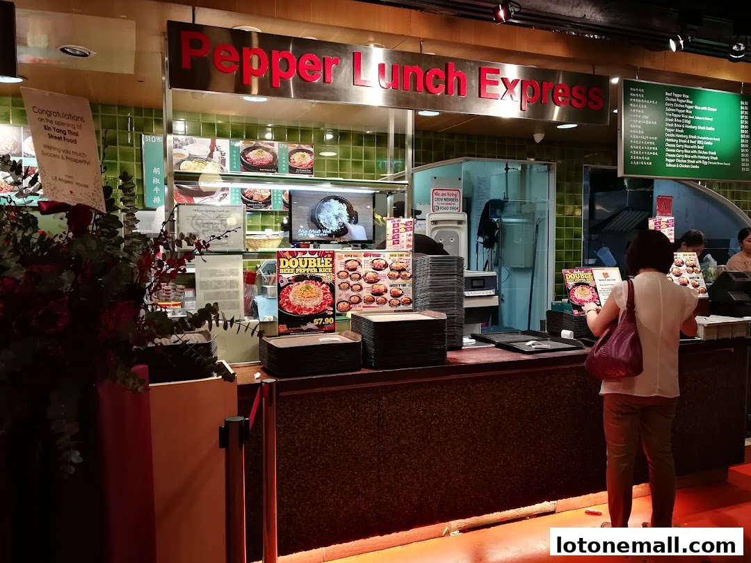 Pepper Lunch Express shop counter with menu displays and customers ordering food.