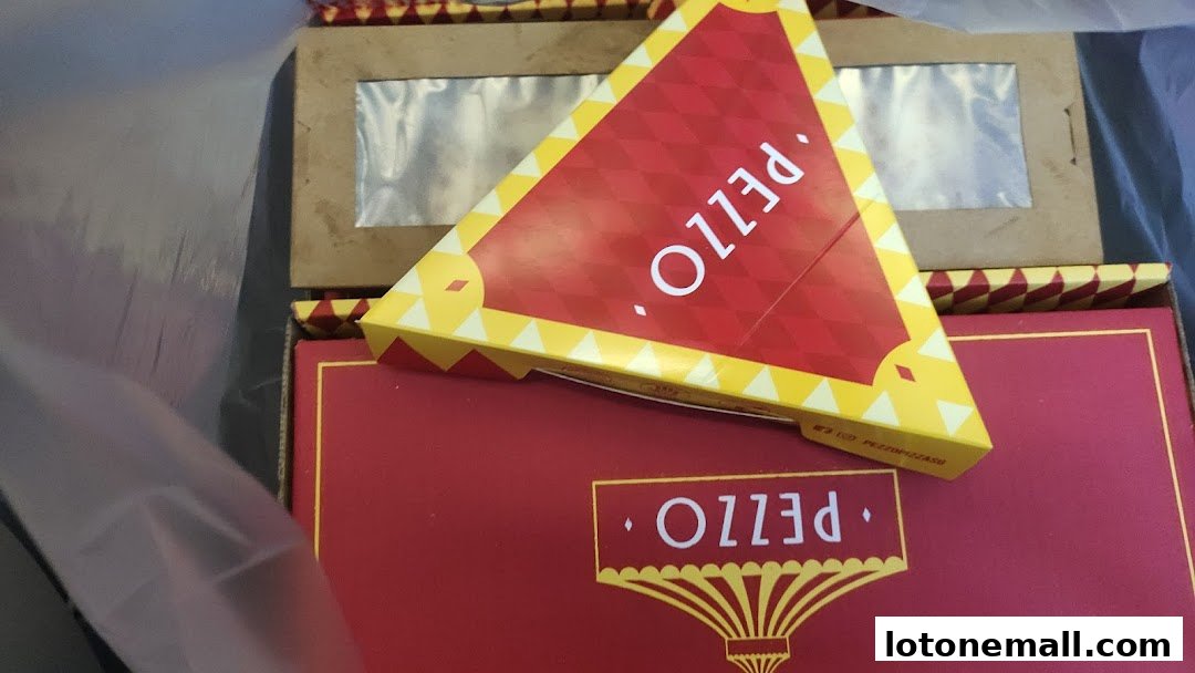 A close-up view of Pezzo pizza boxes, one triangular and one rectangular, with prominent branding.