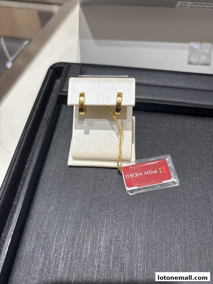 A pair of gold hoop earrings displayed on a white stand with a Poh Heng Jewellery tag.