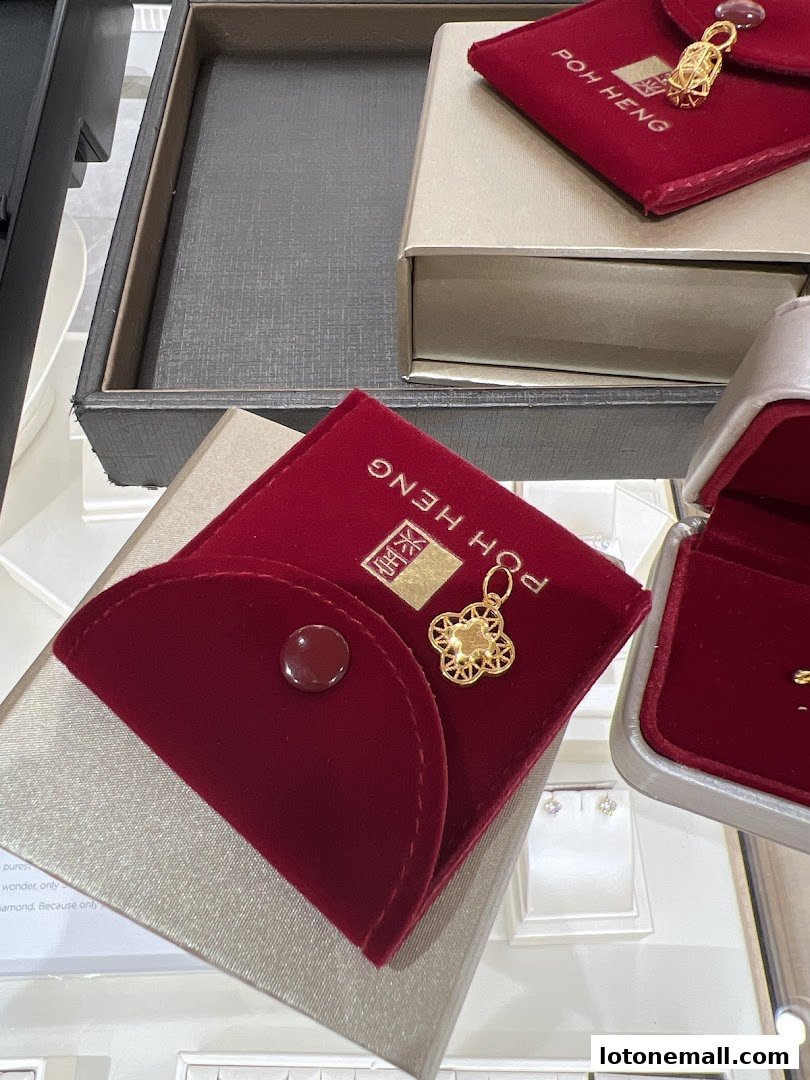 Poh Heng Jewellery displays gold pendants and earrings in elegant red velvet pouches and boxes.