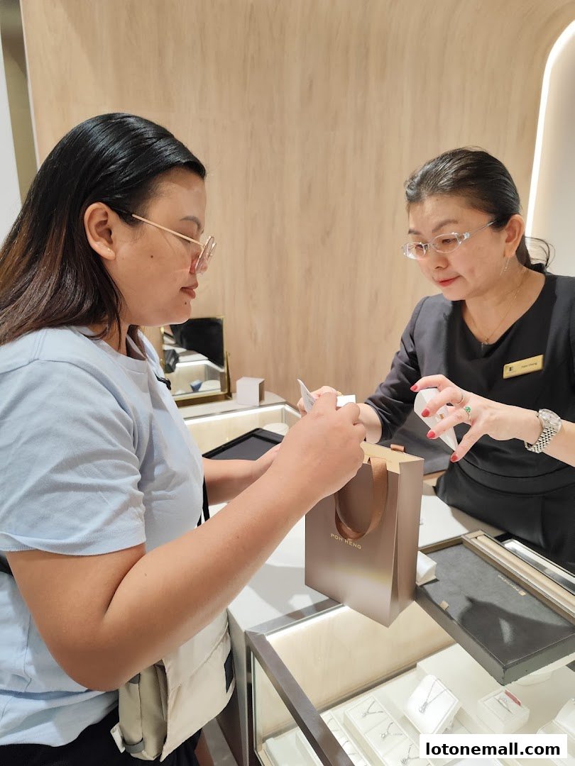 A customer is being served by a sales associate at Poh Heng Jewellery.
