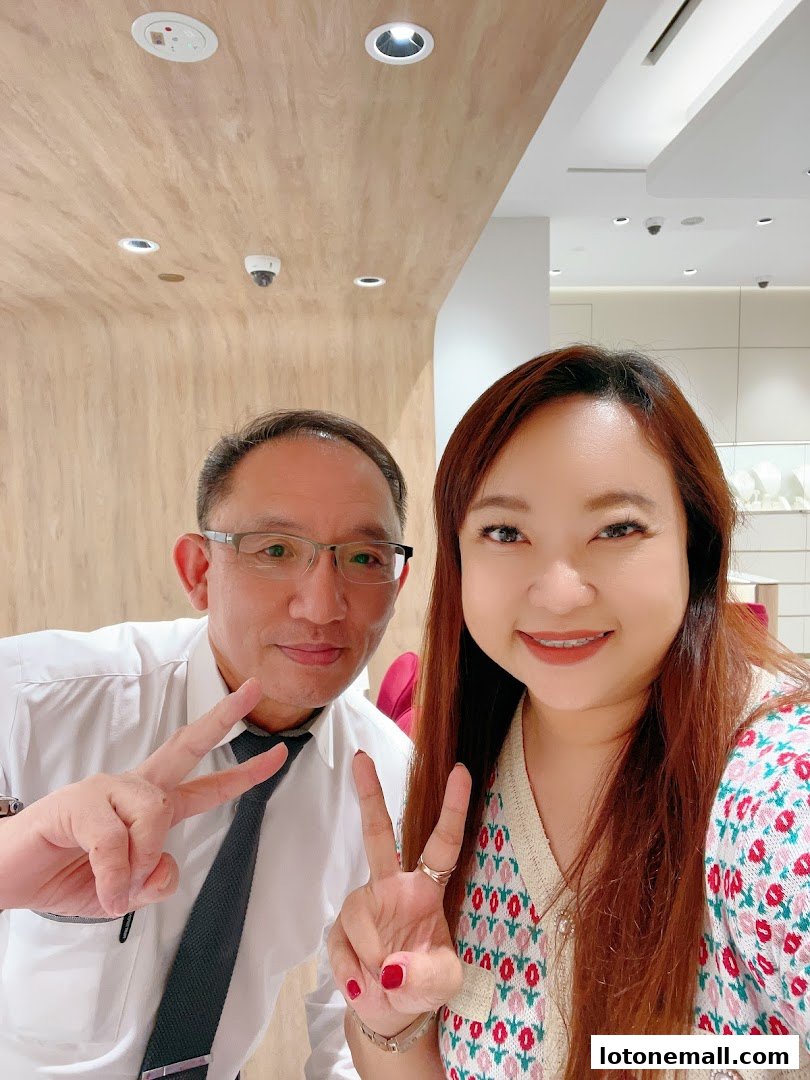 A man and a woman pose for a selfie, both making peace signs.